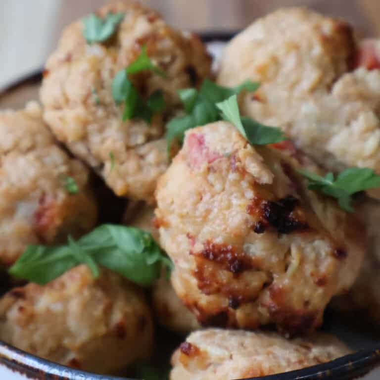 Easy Air Fryer Chicken Meatballs with Lime served on a plate with dipping sauce and lime wedges.