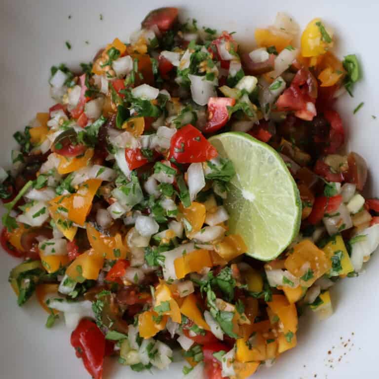 Pico de Gallo sits in a bowl generously coated with cilantro.