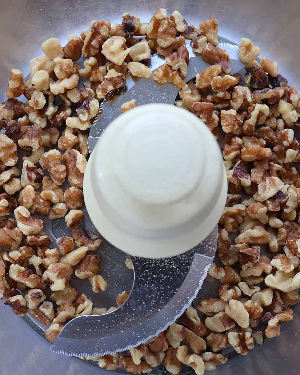 Walnuts in a food processor bowl ready to be pulsed