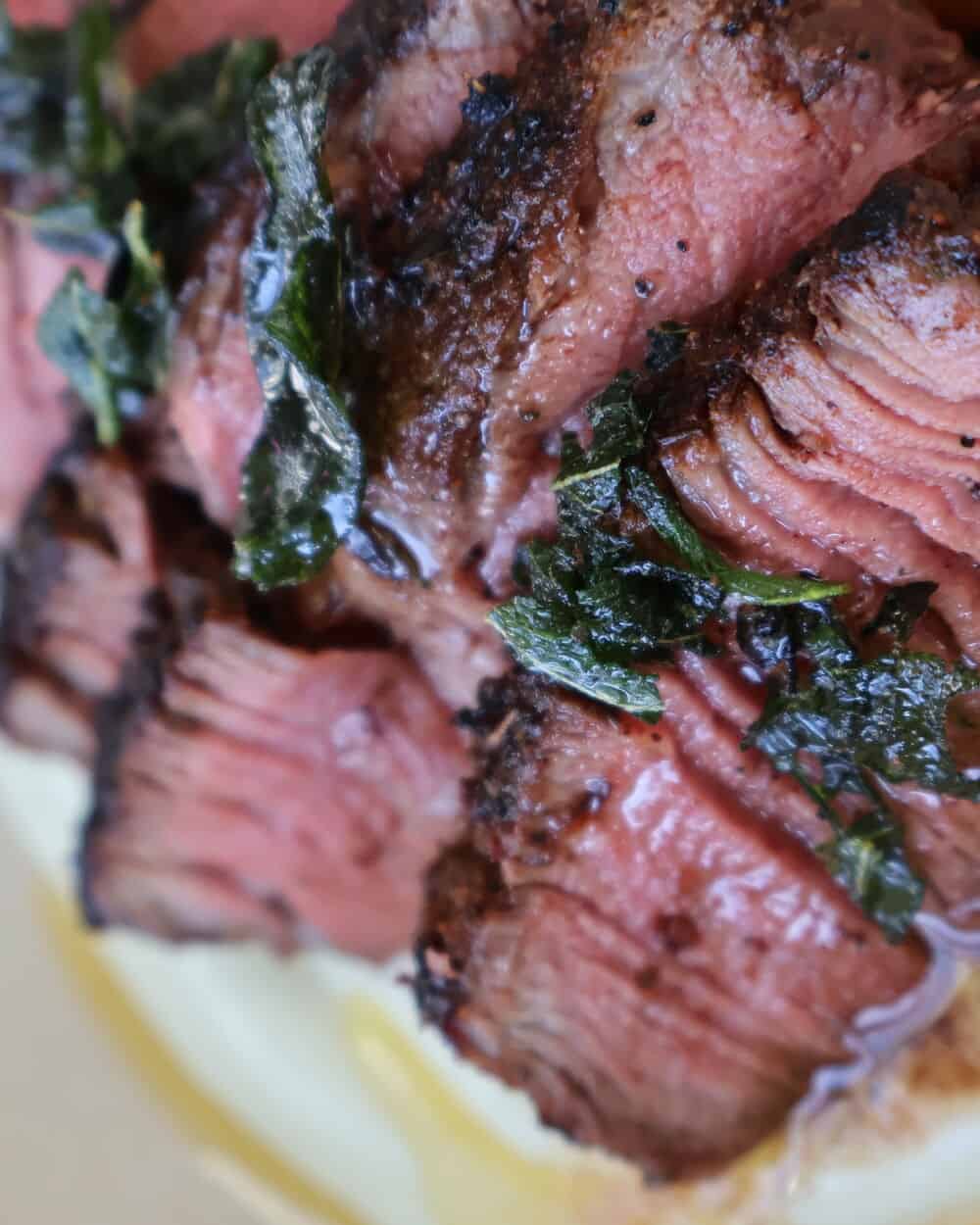 finished blackened filet mignon plated over cauliflower purée with sage brown butter drizzle