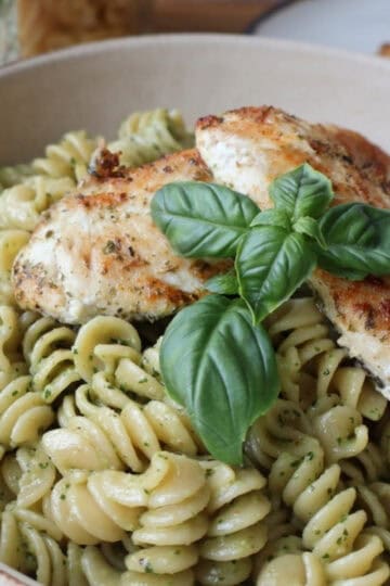 chicken tender pasta recipe with basil walnut pesto in a white bowl