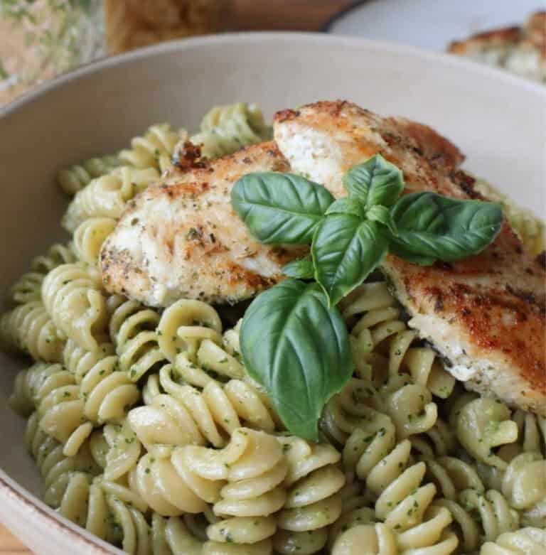 chicken tender pasta recipe with basil walnut pesto in a white bowl
