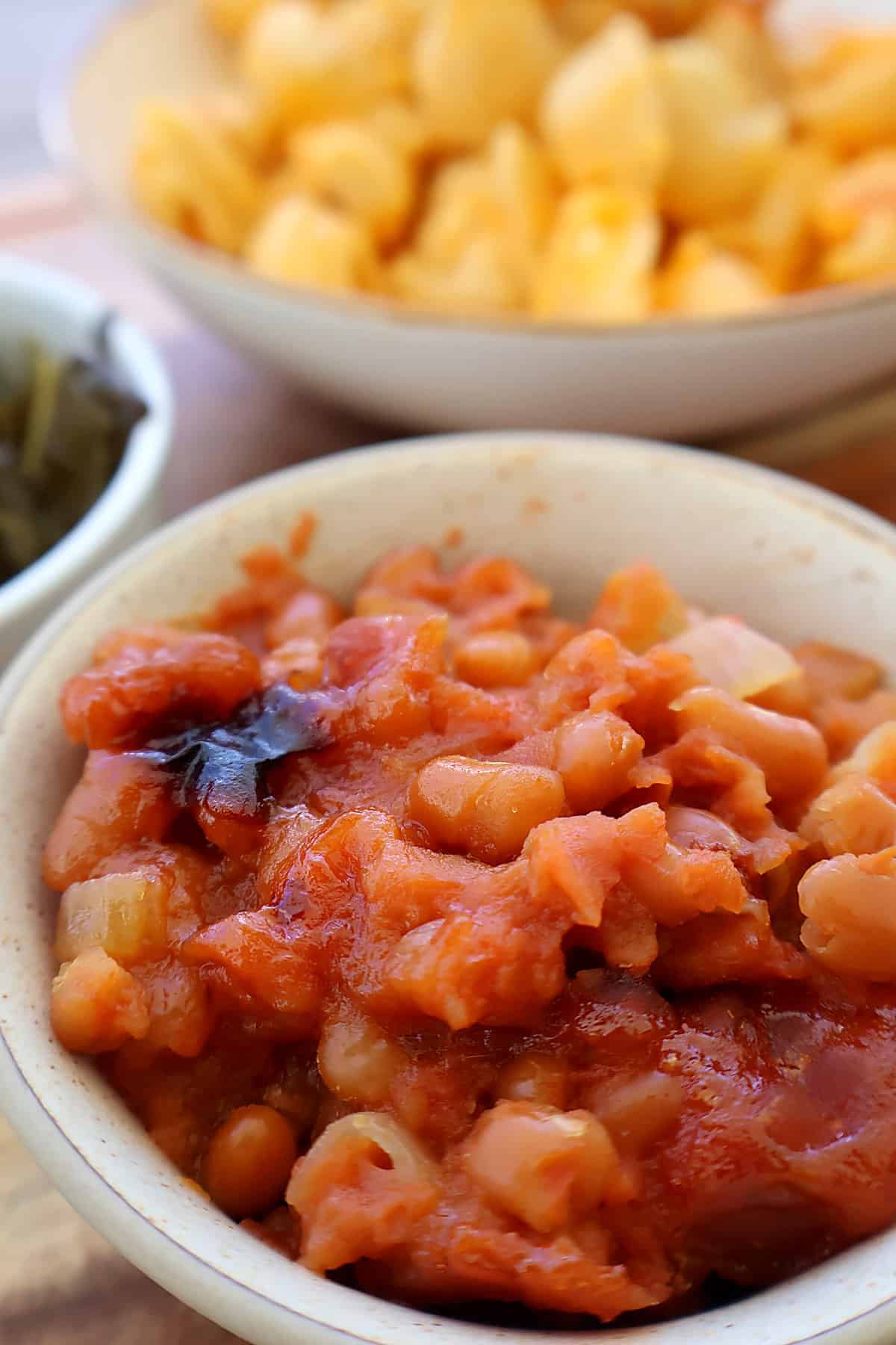 Southern baked beans with canned beans topped with crispy bacon, ready to serve