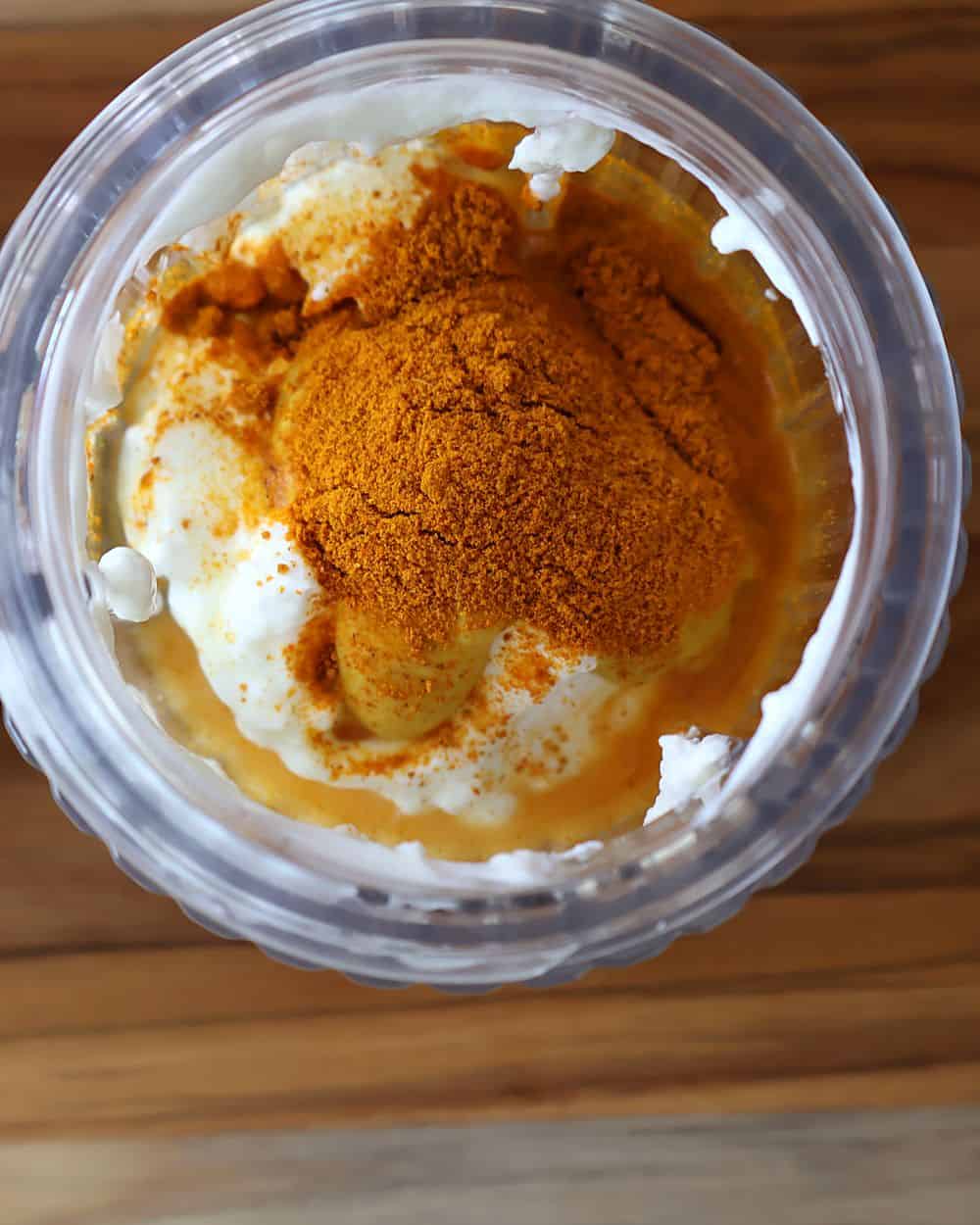 Creamy curry yogurt sauce being whisked in a small bowl