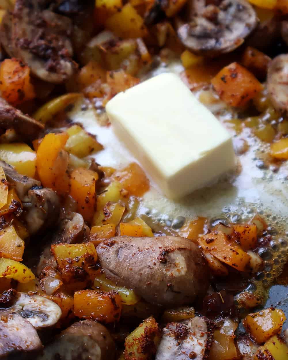 Butter melting into the seasoned vegetables