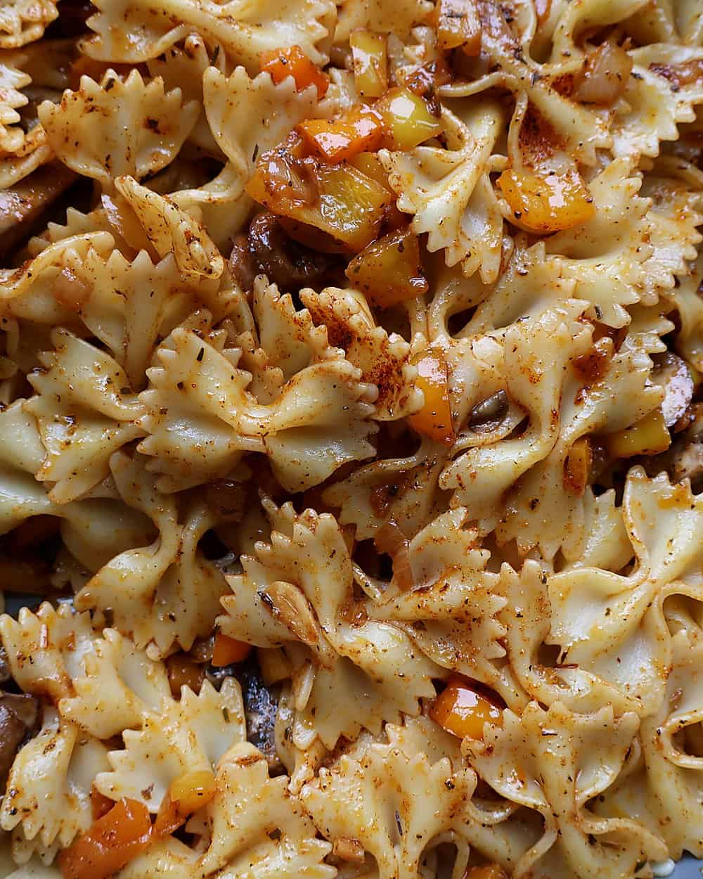 Tossing pasta into the buttery Cajun vegetables