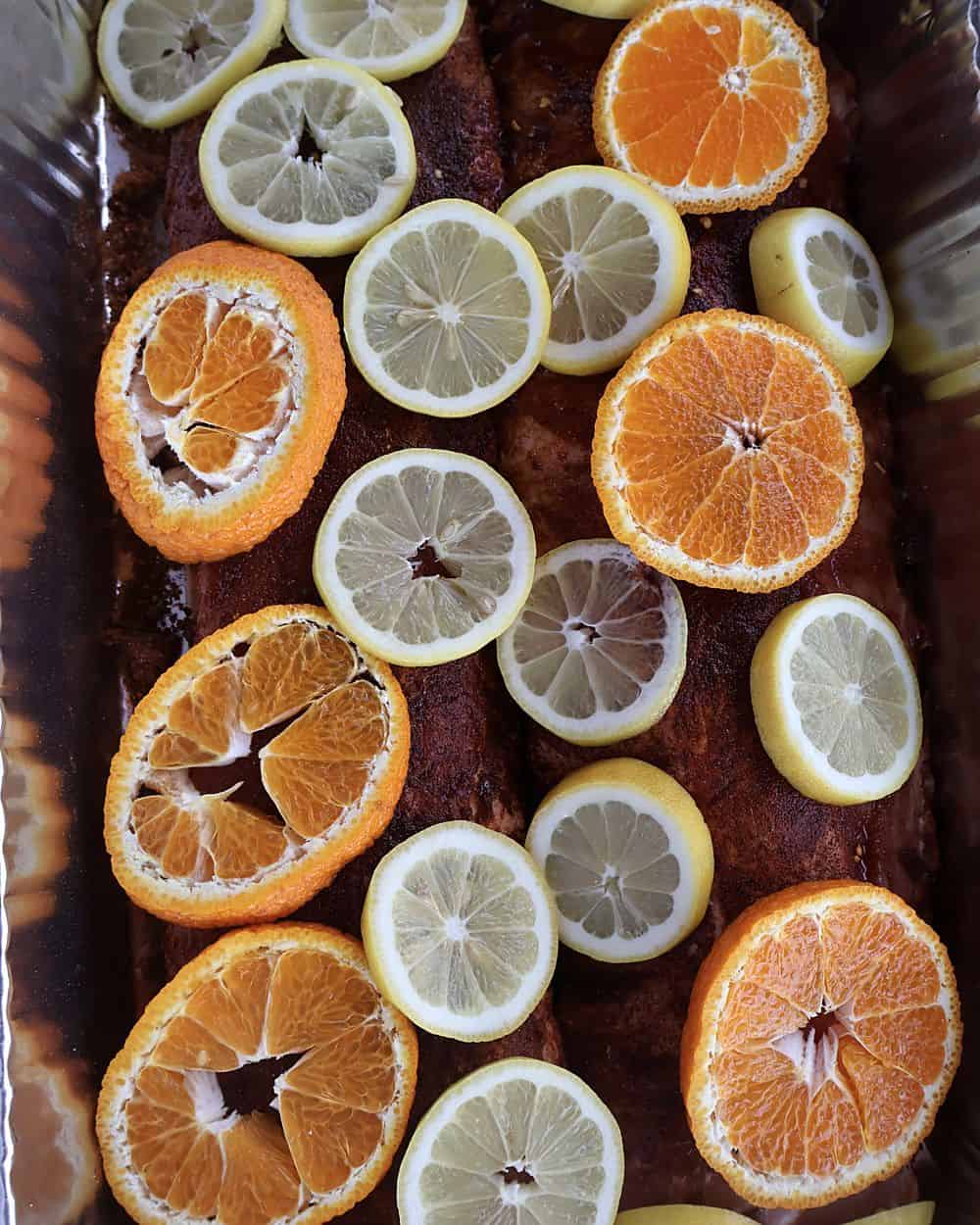 Seasoned ribs topped with sliced lemons and oranges, covered tightly with aluminum foil