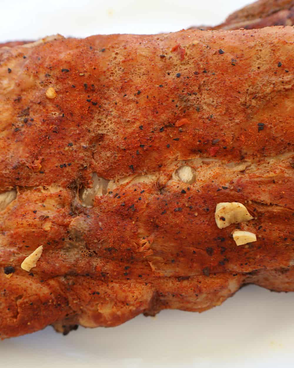 Fully braised ribs resting on a clean tray after coming out of the oven