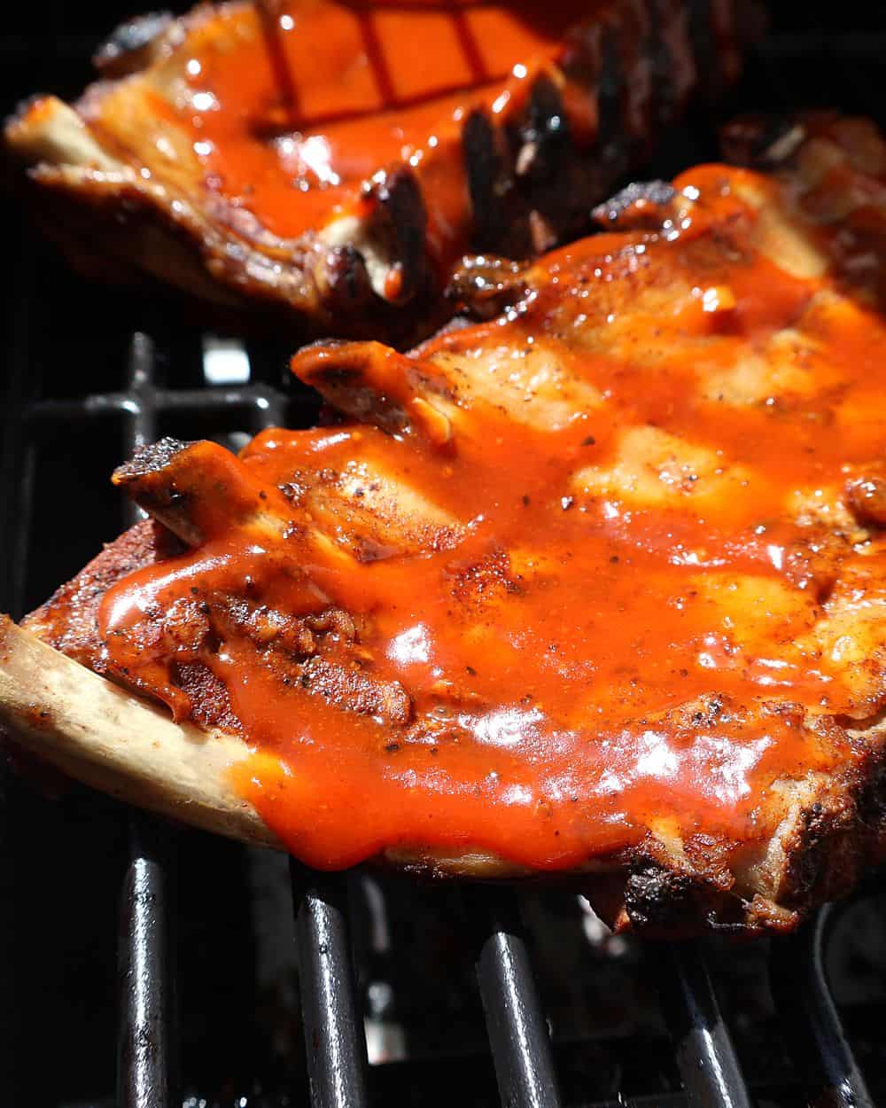 Ribs on the grill with caramelized BBQ sauce, getting a beautiful char