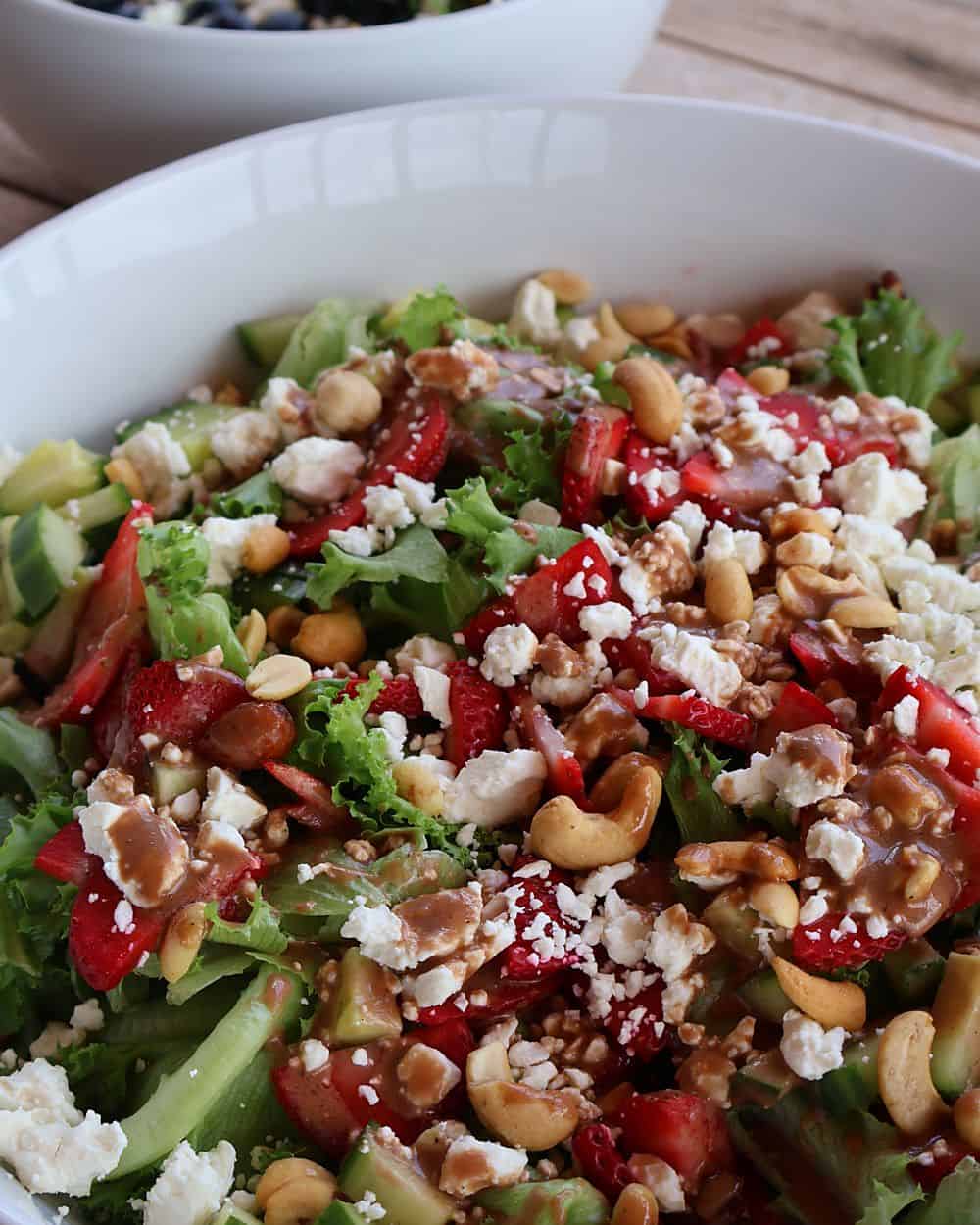 Tossing strawberry salad with balsamic dressing