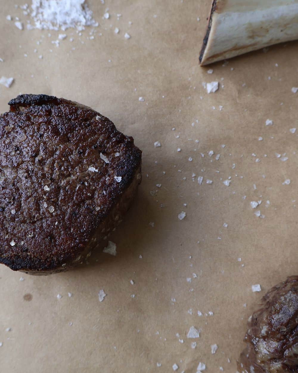 Cast iron skillet with seared filets going into a 500°F oven, instant-read thermometer nearby