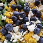 Israeli couscous salad with blueberries, arugula, and feta in a bowl — featured image