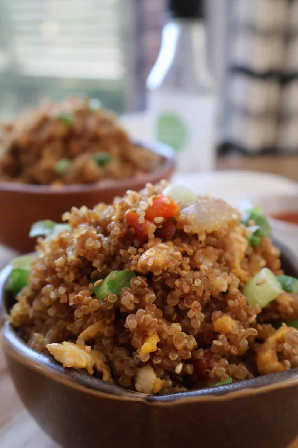 Chicken garlic butter quinoa fried rice served in a brown bowl