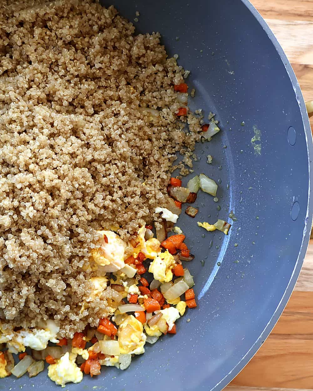 Cooked quinoa frying in a large pan