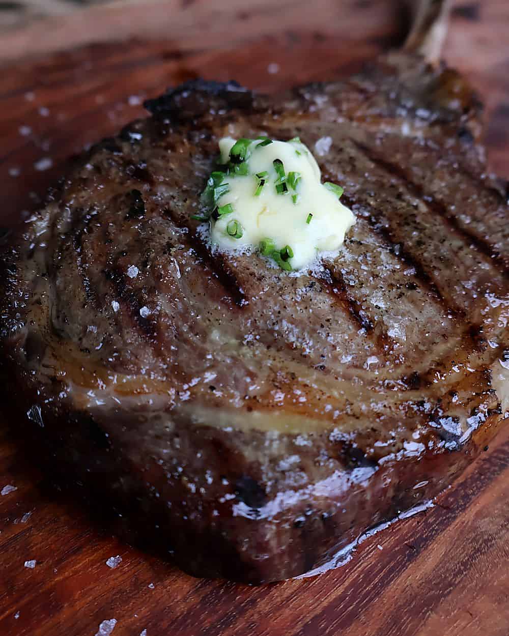 Cow's Rule Bleu Cheese and Chive compound butter melting on top of a freshly seared tomahawk ribeye with Florida Pure Sea Salt flakes