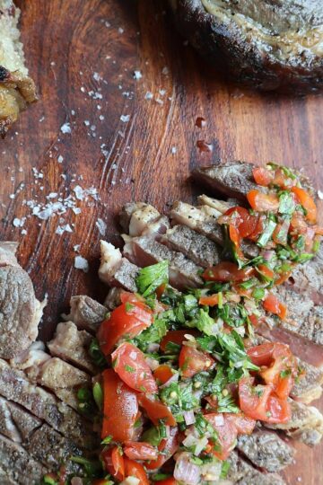 Sliced sous vide ribeye steak with rosemary garnish - featured image