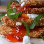Southern fried green tomatoes stacked with whipped goat cheese, red pepper jelly, and fresh basil