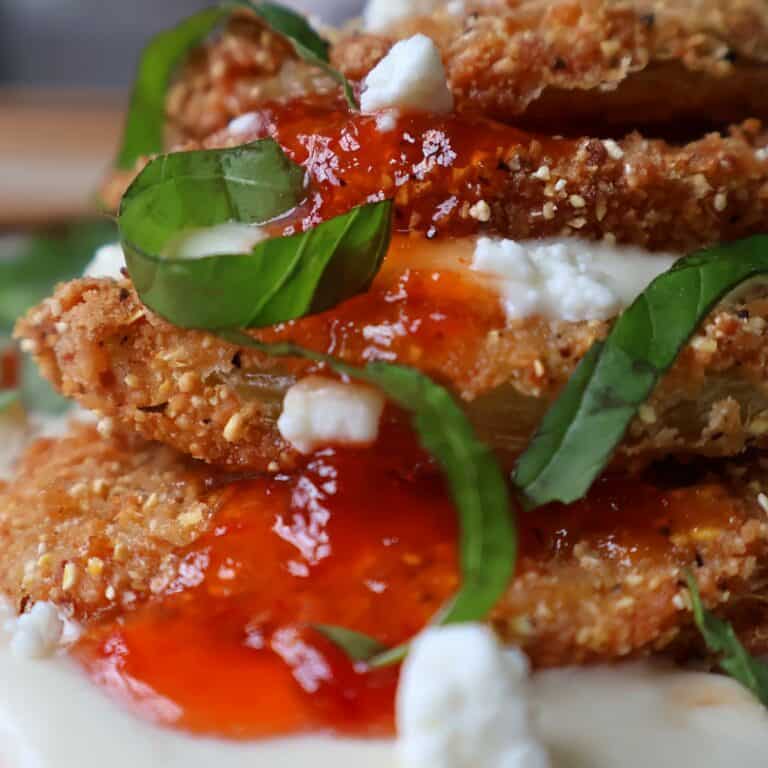 Southern fried green tomatoes stacked with whipped goat cheese, red pepper jelly, and basil