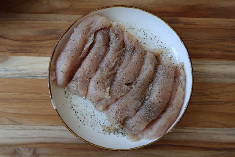 Heating peanut oil in a Dutch oven and seasoning chicken tenders