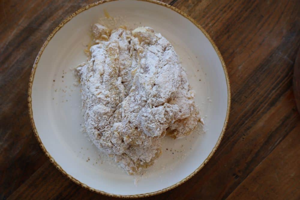 Dredging chicken tenders in seasoned flour