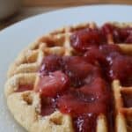 Whole wheat waffles stacked with butter and syrup — featured image