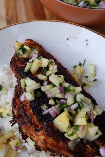 Blackened fish over rice topped with fresh pineapple salsa