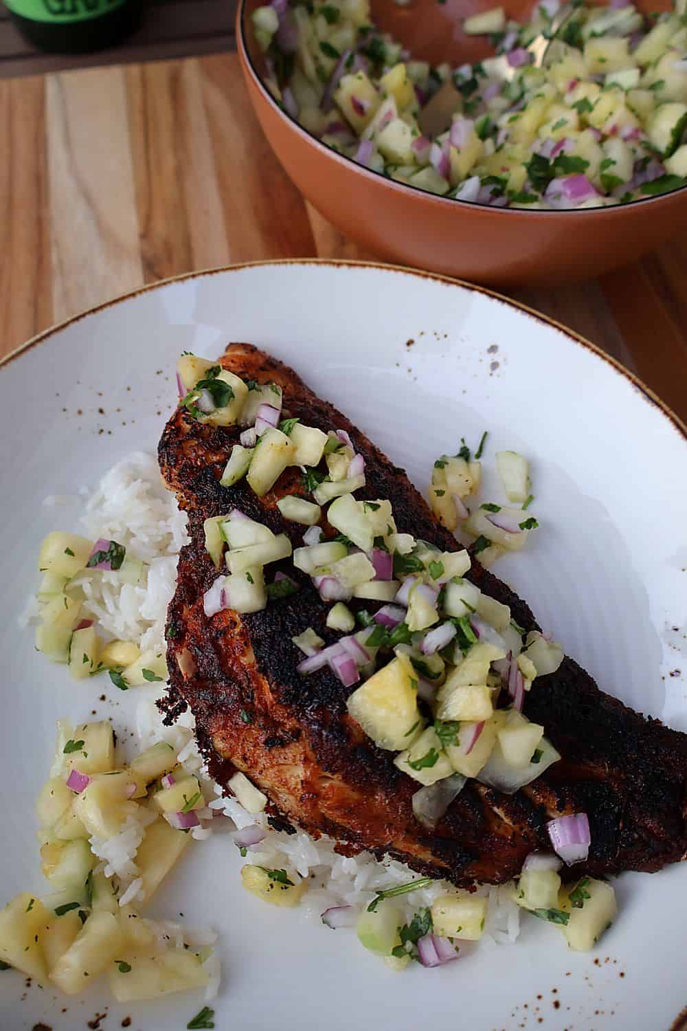 Blackened fish fillet topped with fresh pineapple salsa served over rice