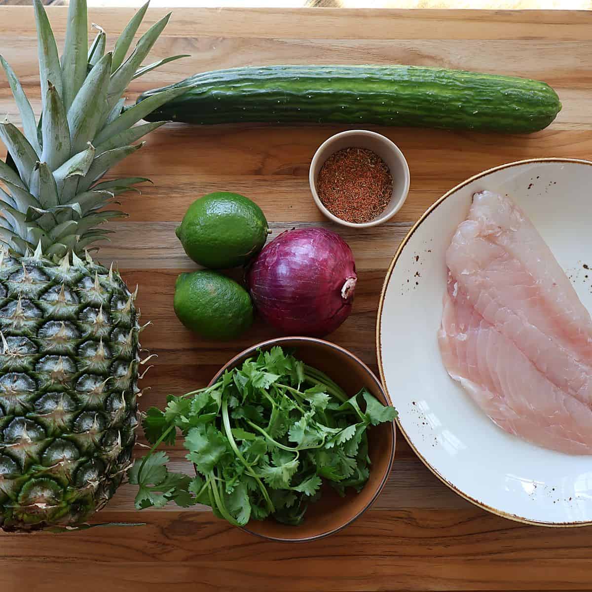 Ingredients for blackened fish with pineapple salsa laid out on a board