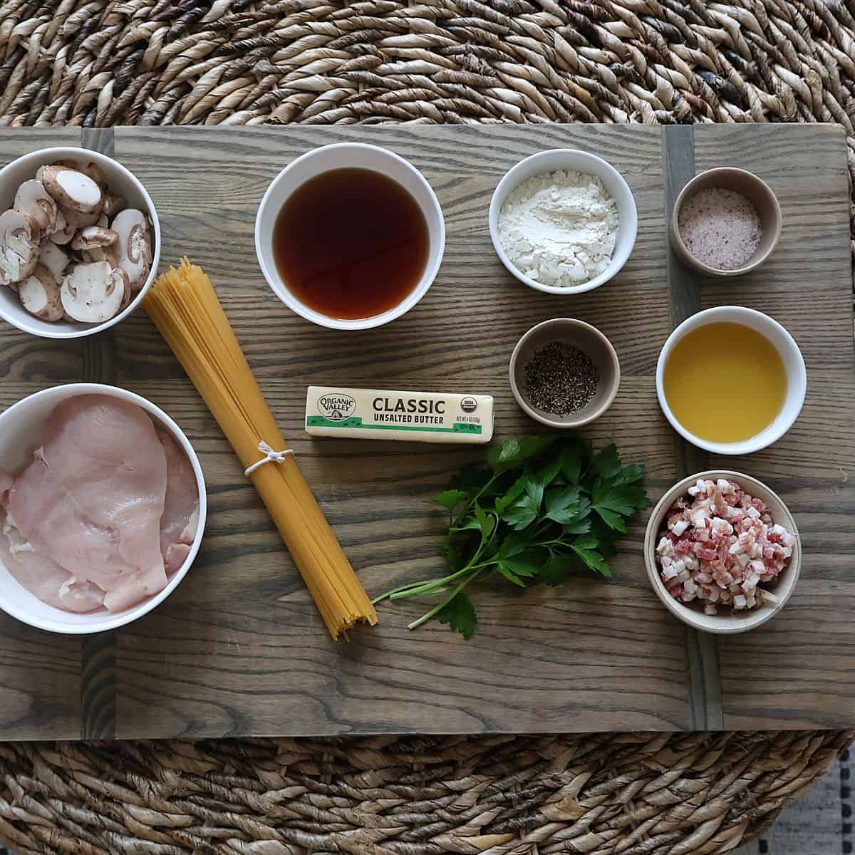 Chicken marsala pasta ingredients flat lay on a wood board