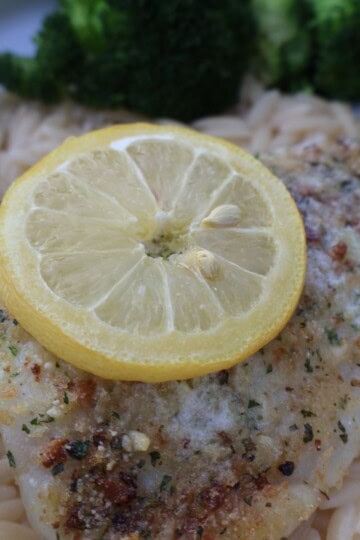 Parmesan crusted fish over lemony orzo with a lemon slice and broccoli
