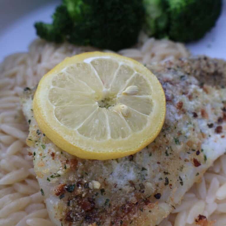 Parmesan crusted fish over lemony orzo with a lemon slice and broccoli
