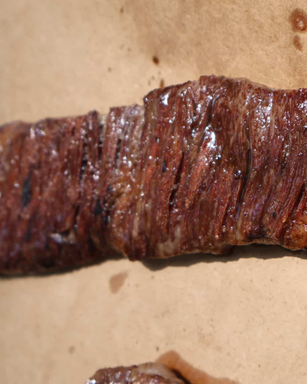 Wagyu skirt steak sliced thin against the grain on a wood board, finished with flaky sea salt