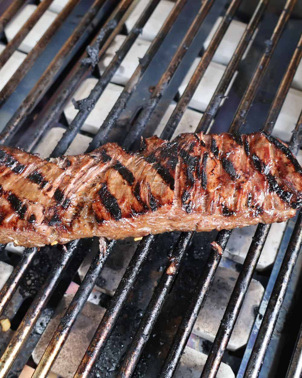 Wagyu skirt steak searing on a hot grill with char marks