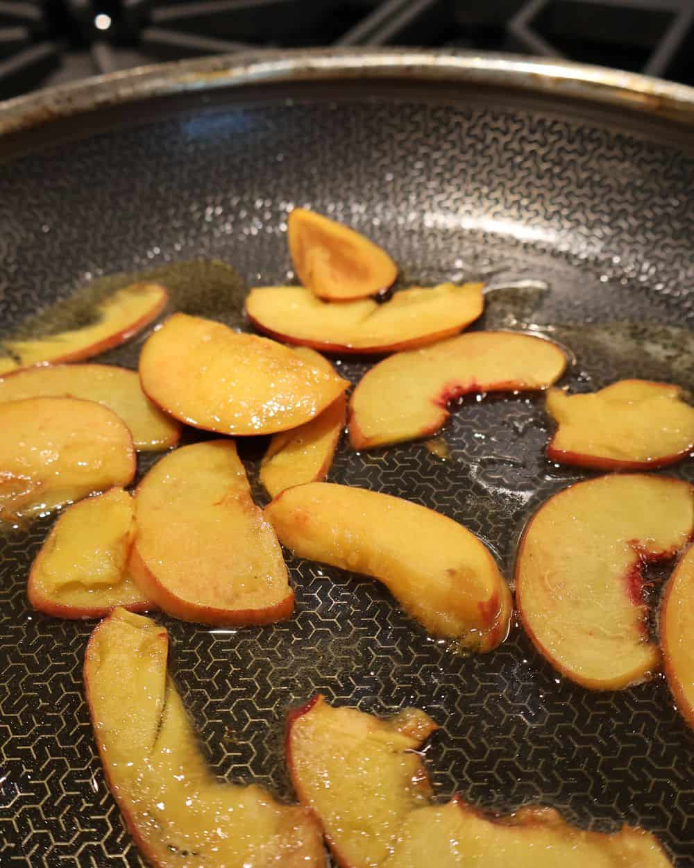 Peach halves charring on the grill for hot honey chicken