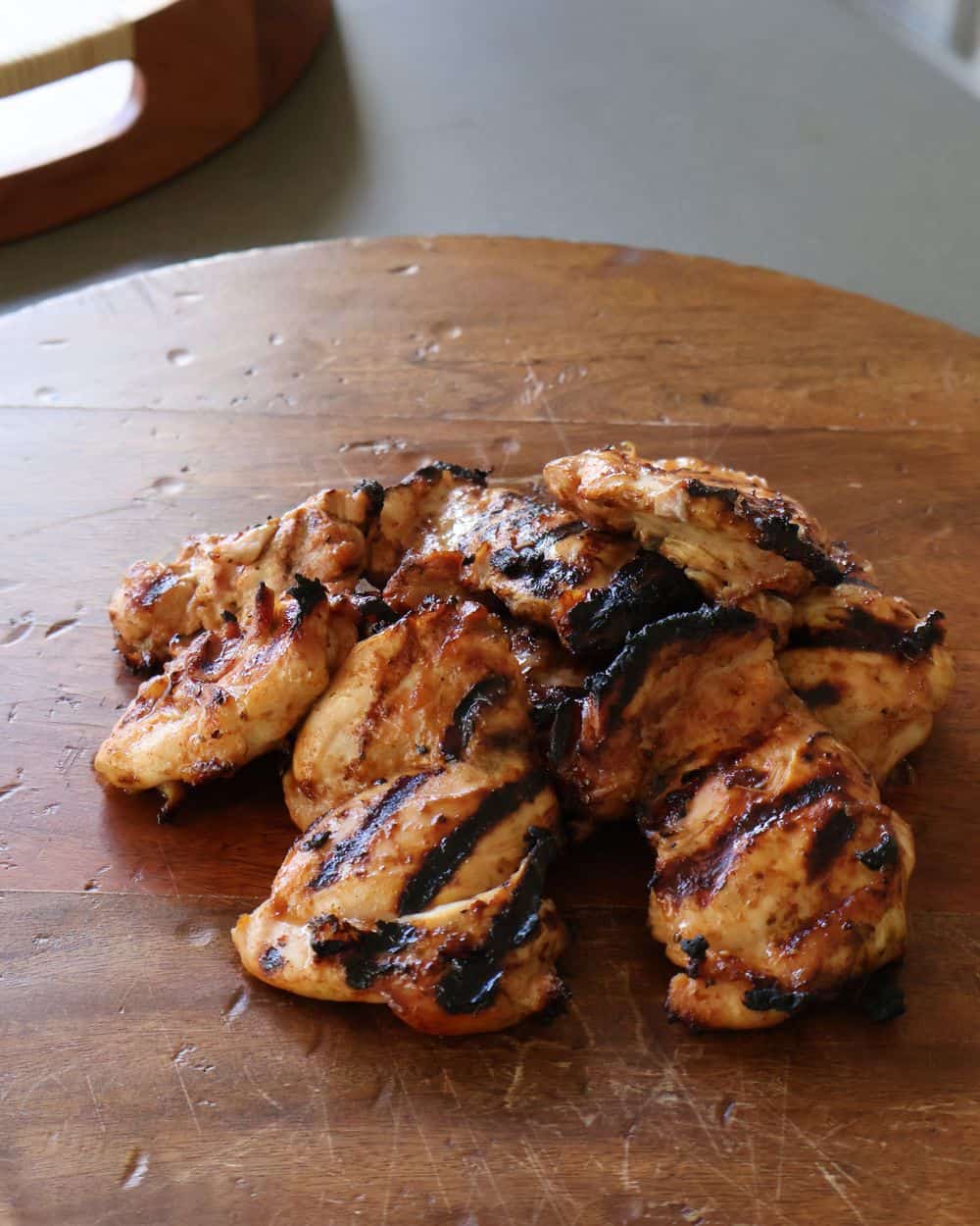 Chicken thighs grilling with char marks for hot honey chicken recipe