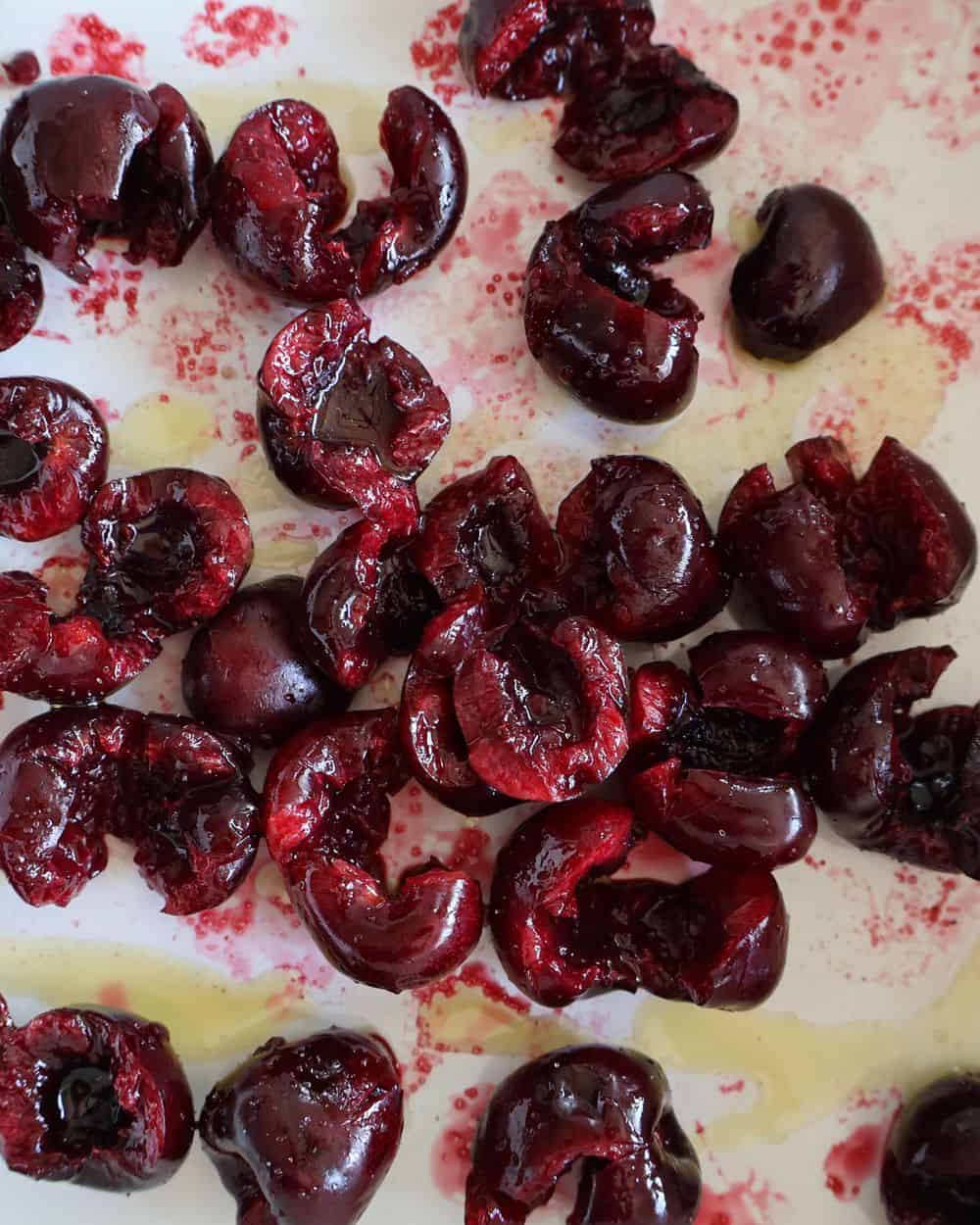 Balsamic roasted cherries in a white roasting pan after 18 minutes in the oven