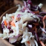 Creamy coleslaw with red and green cabbage and carrot in a wooden bowl