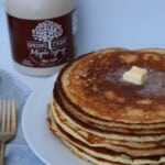 A stack of high protein cottage cheese pancakes on a white plate with butter melting on top