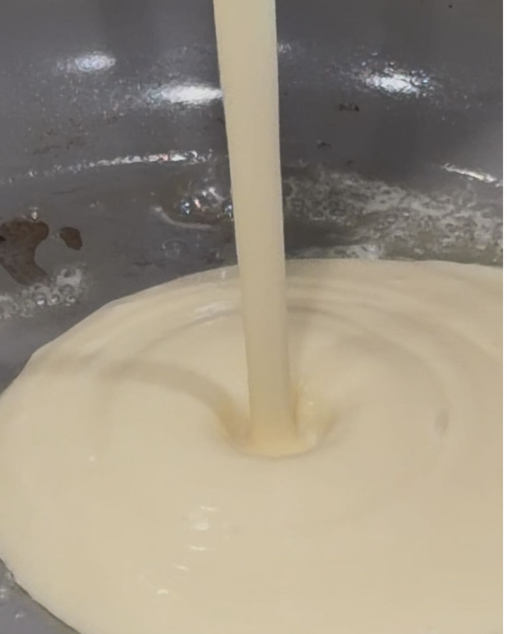 Smooth cottage cheese pancake batter being poured into a buttered skillet