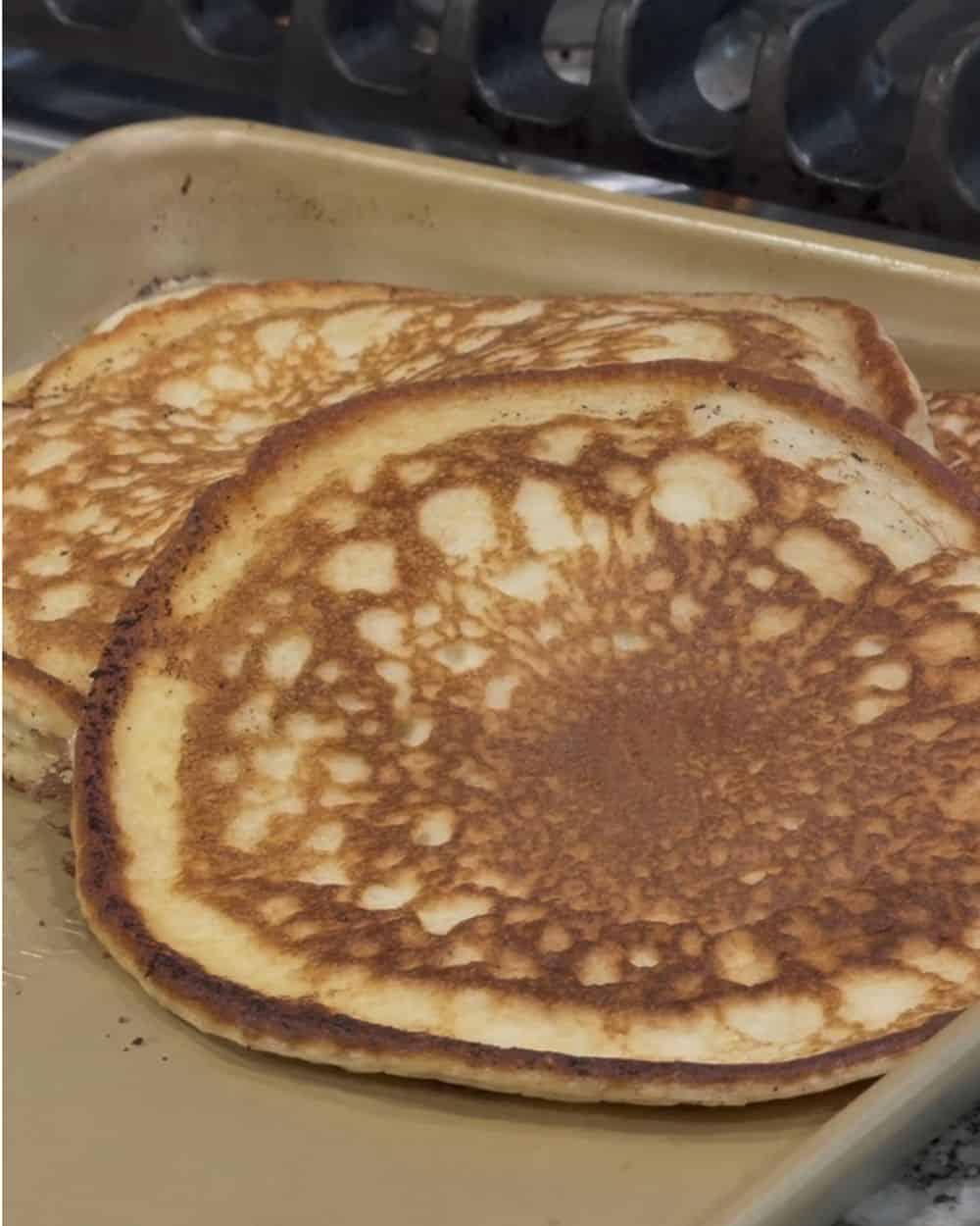 Golden brown cottage cheese pancakes cooling on a sheet pan