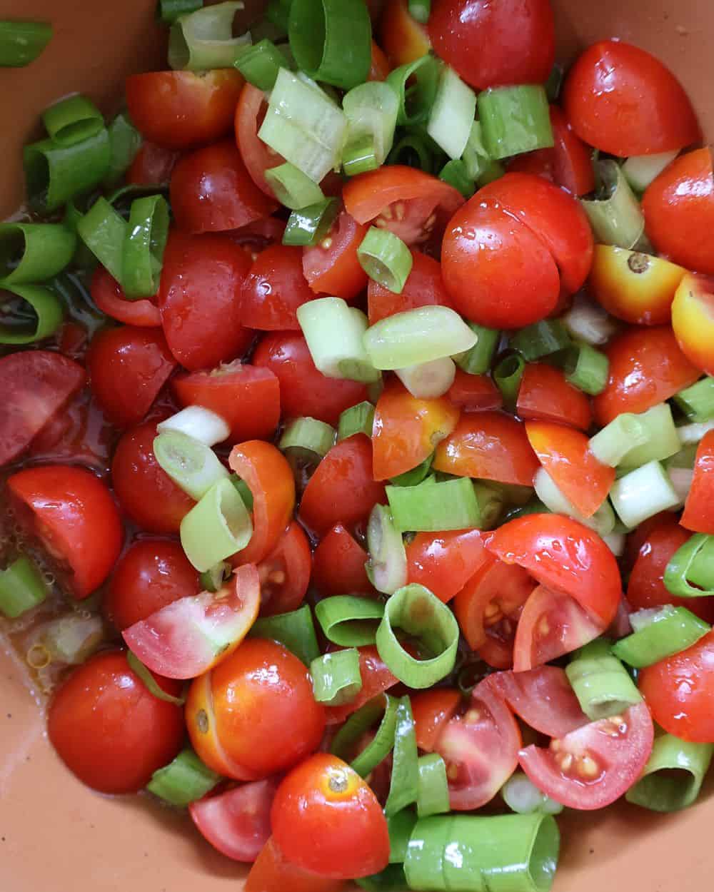 Cherry tomatoes, green onion, and tequila marinating for the sea bass topping